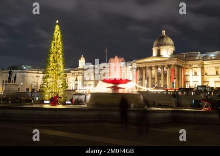 LONDRA, UK - 6th DEC 2022: Trafalgar Square a Londra a Natale. Mostra un albero di Natale, bancarelle di mercato e una fontana. Le persone possono essere viste. Foto Stock