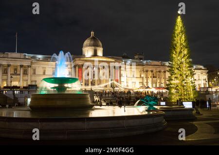 LONDRA, UK - 6th DEC 2022: Trafalgar Square a Londra a Natale. Mostra un albero di Natale, bancarelle di mercato e una fontana. Le persone possono essere viste. Foto Stock