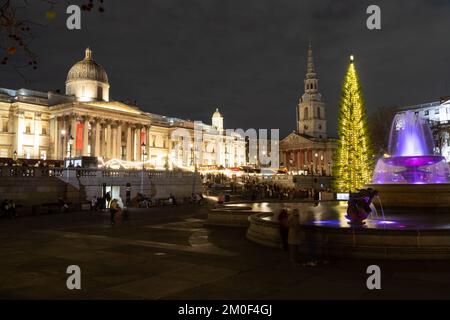 LONDRA, UK - 6th DEC 2022: Trafalgar Square a Londra a Natale. Mostra un albero di Natale, bancarelle di mercato e una fontana. Le persone possono essere viste. Foto Stock