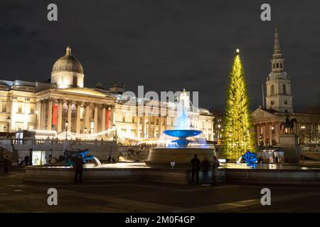 LONDRA, UK - 6th DEC 2022: Trafalgar Square a Londra a Natale. Mostra un albero di Natale, bancarelle di mercato e una fontana. Le persone possono essere viste. Foto Stock