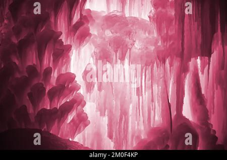 Enormi ghiaccioli. Grandi blocchi di acqua ghiacciata. Sfondo ghiaccio blu. Cascata di ruscello ghiacciato. Immagine colorata in Viva Magenta, colore del 2023° anno Foto Stock