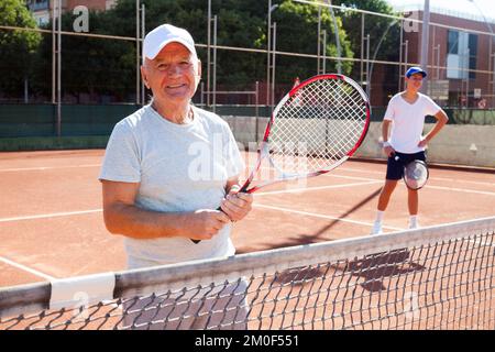 uomo anziano in posa sul campo da tennis Foto Stock