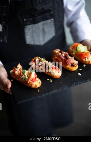 Eclairs con salmone, verdure fresche ed erbe aromatiche, spuntini gourmet. Foto Stock