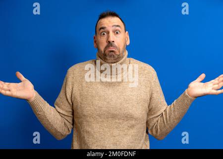 Esitante bewildered fashionamble uomo pieno di dubbi, deve decidere o scegliere tra due proposte, labbra a portafoglio, ha espressione indecisa Foto Stock