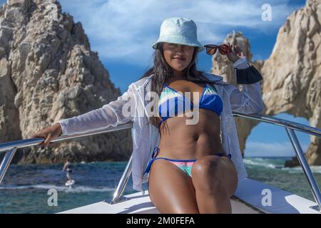 Giovane bella ragazza messicana donna in barca vicino alle formazioni rocciose intorno all'Arco di Cabo San Lucas, Messico. Foto Stock