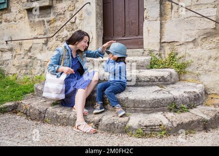 Madre e piccolo bel bambino ragazzo seduto su scale di pietra antica Foto Stock