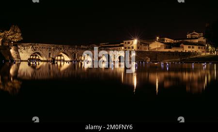 Nella foto si vede il Ponte Tiberio a Rimini. Catturato di notte Foto Stock