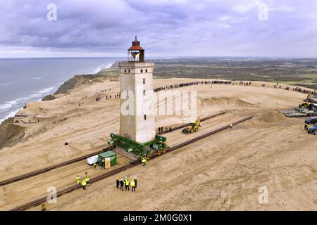 Il faro di Rubjerg Knude si muove su "pattini a rotelle" e su rotaie metalliche a Loenstrup, Jutland settentrionale, Danimarca, martedì 22 ottobre, 2019. Il faro alto 23 metri e vecchio di 120 anni si sposta di circa 70 metri nell'entroterra. Il faro doveva essere spostato perché le onde del mare mangiano ogni anno circa due - quattro metri della costa di fronte al faro. Se il faro non venisse spostato, si schianterebbe in mare tra cinque o dieci anni. Foto Stock