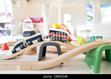 un treno elettrico in legno e un giocattolo ferroviario per bambini in un posto di guardia e un parco giochi al coperto. Foto Stock