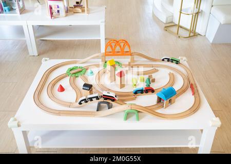 un treno elettrico in legno e un giocattolo ferroviario per bambini in un posto di guardia e un parco giochi al coperto. Foto Stock