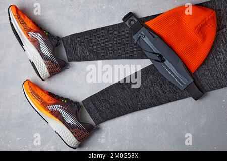 Un cappello caldo lavorato in maglia arancione, leggings sportivi caldi, un pack di fanny w Foto Stock