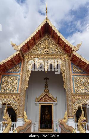Vista di Viharn Luang o della principale facciata di vihara con una bella scultura in legno dorato presso il famoso tempio buddista Wat Phra Singh, Chiang mai, Thailandia Foto Stock