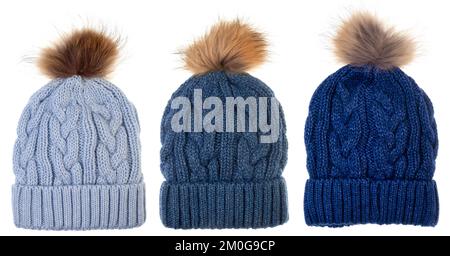 Cappelli di bobble invernali di lana blu decorati con ornamento in maglia di cavo isolato su sfondo bianco. Berretto in lana fatto a mano con fake pon pom in pelliccia Foto Stock