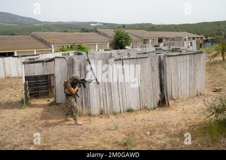 Il giocatore Airsoft in posizione tattica offensiva avanza per prendere posizione. Lo sport che mette alla prova le tue abilità tattiche Foto Stock