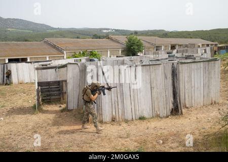 Il giocatore Airsoft in posizione tattica offensiva avanza per prendere posizione. Lo sport che mette alla prova le tue abilità tattiche Foto Stock