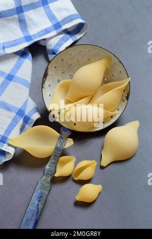 Conchiglione e conchiglie piccole con mestolo setaccio, pasta conchiglia, pasta Foto Stock