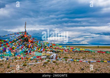 Bandiere in preghiera con vista sul lago di Manarasowar, lungo la strada meridionale verso il Tibet occidentale, in Asia Foto Stock