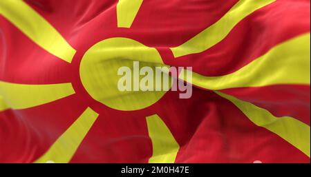 Vista ravvicinata della bandiera nazionale della Macedonia settentrionale che sventola nel vento. La Repubblica del Nord Macedonia è un paese dell'Europa sudorientale. Tessuto testurizzato b Foto Stock