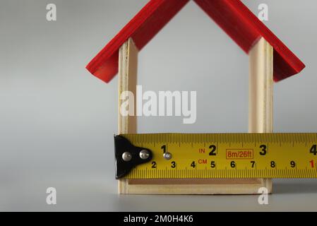 Immagine a fuoco selettivo della casa in miniatura e del nastro di misurazione con spazio di copia. Concetto di ristrutturazione della casa Foto Stock