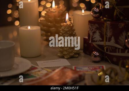i regali confezionati con foto si trovano sul tavolo accanto a candele e biglietti illuminati Foto Stock