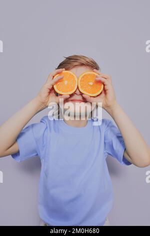 6 anno ragazzo grigio con arance Foto Stock