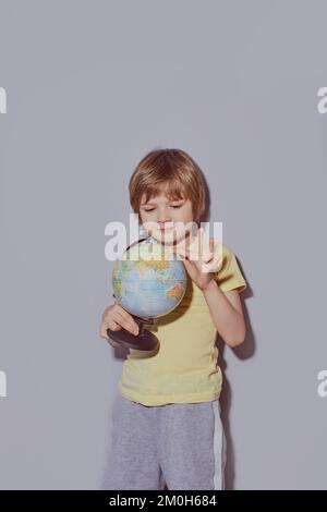 6 anno ragazzo in grigio con un globo Foto Stock