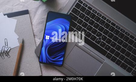 Dobrich, Bulgaria – 2022 novembre 26: Telefono cellulare su un laptop con il logo Microsoft e Windows 11. Concetto editoriale illustrativo per il software Foto Stock
