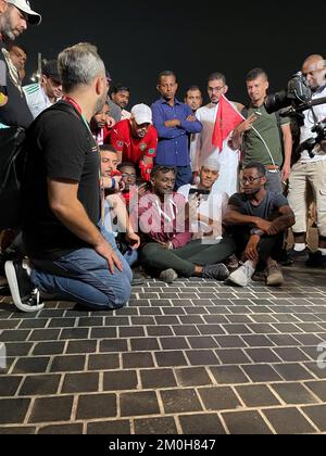 Gli appassionati di calcio che guardano la partita Marocco contro Spagna fuori dal Education City Stadium, Qatar, durante la Coppa del mondo FIFA 2022. Ci erano scene tese più presto fuori dello stadio come la polizia antisommossa ha messo i loro caschi, la polizia montata ed i cani si sono mossi in avanti ed almeno due persone sono state tirate via dalle forze di sicurezza. Decine di tifosi marocchini si trovavano fuori dallo stadio mentre la loro squadra giocava in Spagna. Data immagine: Martedì 6 dicembre 2022. Foto Stock