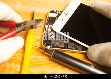 Vista dall'alto di un tecnico che ripara uno smartphone Foto Stock