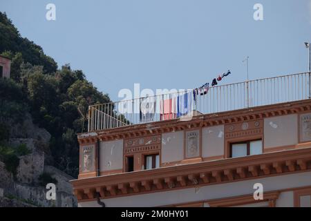 Abbigliamento da spiaggia e asciugamano su una linea su un tradizionale balcone sul tetto della città di Amalfi Italia Foto Stock