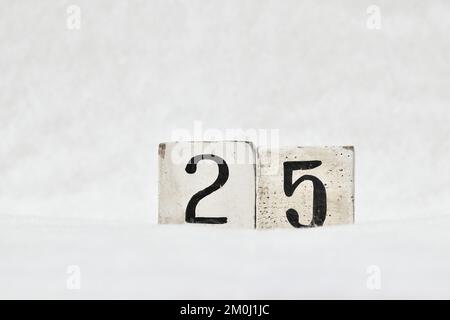 25 numero di calendario in blocco di legno vintage su sfondo bianco neve, spazio copia. Salva la data di natale, compleanno, anniversario, giorno speciale Foto Stock