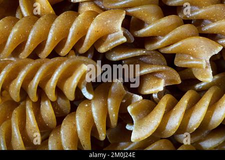 Consistenza di pasta fusilli cruda come sfondo. Un primo colpo di pasta. Macro photo.pasta cruda fusilli. Foto Stock