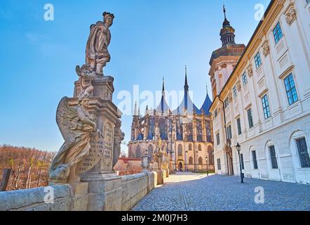 Storica statua di San Floriano in pietra su via Barborska, contro la straordinaria cattedrale gotica di Santa Barbara, Kutna Hora, Repubblica Ceca Foto Stock