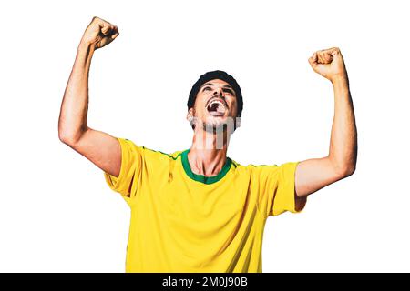 Giocatore brasiliano di calcio che celebra su uno sfondo bianco. Drammatico ritratto di un giocatore di calcio nero che tiene la bandiera. Foto Stock