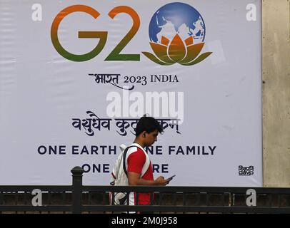 Un uomo controlla il suo telefono mentre cammina oltre un logo G20 stampato su un banner a Mumbai. Il summit del G20 o il Gruppo dei venti summit offre l'opportunità di presentare l'India al mondo. Porterà grandi opportunità per il turismo e stimolerà l'economia locale. Il primo ministro Narendra modi ha cercato il sostegno dei leader dell'opposizione di tutti i partiti politici per renderlo un successo. Foto Stock