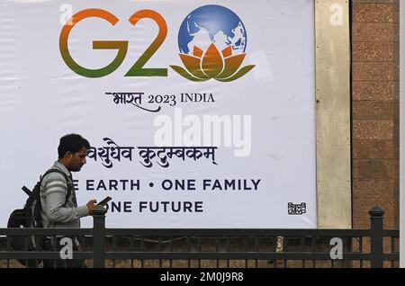 Mumbai, India. 06th Dec, 2022. Un uomo controlla che il suo telefono passi oltre un logo G20 stampato su uno striscione a Mumbai. Il summit del G20 o il Gruppo dei venti summit offre l'opportunità di presentare l'India al mondo. Porterà grandi opportunità per il turismo e stimolerà l'economia locale. Il primo ministro Narendra modi ha cercato il sostegno dei leader dell'opposizione di tutti i partiti politici per renderlo un successo. (Foto di Ashish Vaishnav/SOPA Images/Sipa USA) Credit: Sipa USA/Alamy Live News Foto Stock