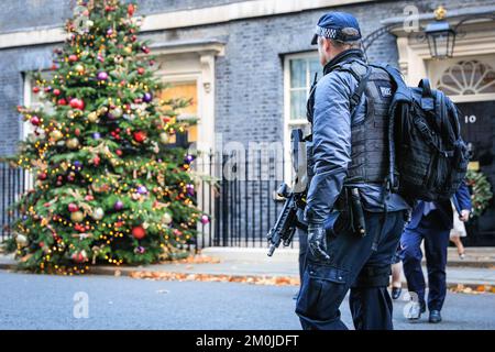 Londra, Regno Unito. 06th Dec, 2022. Un armata Metropolitan Police Office cammina lungo Downing Street oltre l'albero di Natale. I ministri del governo di Sunak partecipano oggi alla riunione settimanale del gabinetto al 10 di Downing Street a Westminster. Credit: Imageplotter/Alamy Live News Foto Stock