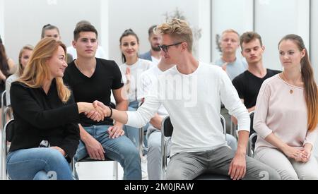 i colleghi si salutano durante un seminario aziendale Foto Stock