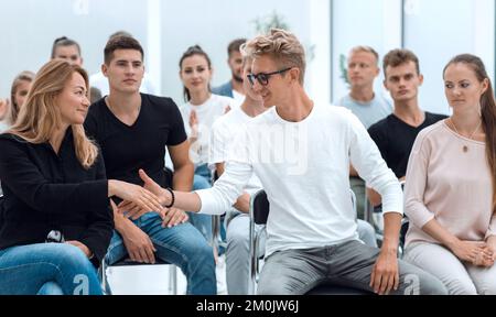 i colleghi si salutano durante un seminario aziendale Foto Stock