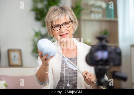 la donna anziana ha trasformato l'hobby di maglia nell'insegnamento da in linea Foto Stock