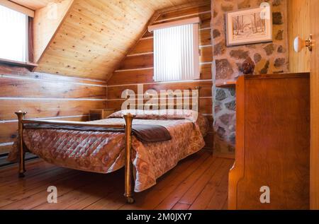 Antico letto in ottone e comò nella camera da letto al piano superiore all'interno del 1978 ha costruito una replica della vecchia casa in legno decorata in stile cottage canadese del 1800. Foto Stock