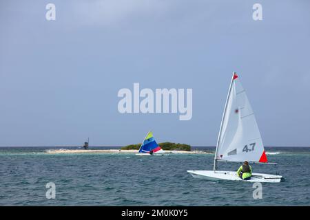 ORANJESTAD, ARUBA - 27 MARZO 2022: Piccole barche a vela laser e di pesce sole che navigano lungo la costa a Surfside Beach a Oranjestad su Aruba Foto Stock