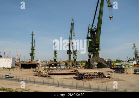 Costruzione industriale presso il cantiere navale di Danzica, ex cantiere di Lenin, officina di prefabbricazione e gru pesanti grande cantiere polacco. Gru nello storico cantiere navale di Danzica, sede di Solidarity Polska Foto Stock