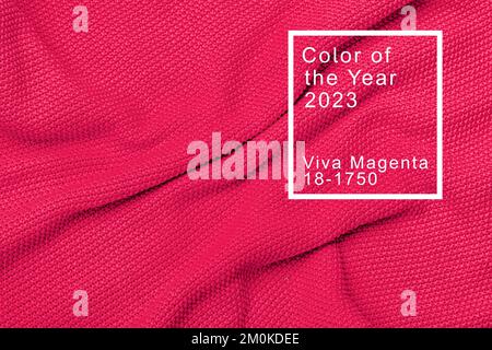 La texture del caldo maglione lavorato a maglia. Splendido motivo a maglia fatto a mano. Dimostrazione Pantone colore dell'anno 2023 viva magenta. Foto Stock