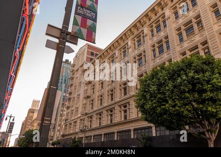 Un'inquadratura ad angolo basso di un edificio nel centro di Los Angeles e un cartello con la scritta "Fashion District" Foto Stock