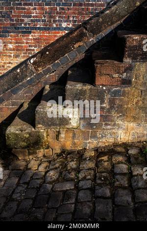 Scalini di cemento usati vicino alla vecchia parete Foto Stock