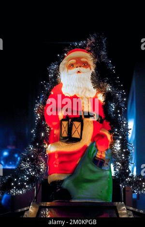 Figura illuminata di Babbo Natale alla fiera di Natale di Monaco di notte con sfondo scuro Foto Stock