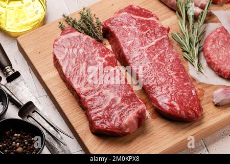 Bistecche e spezie di manzo in marmo di prima qualità. Bistecca allo striploin crudo Foto Stock