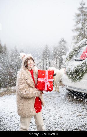 Donna viaggia in auto durante le vacanze invernali Foto Stock