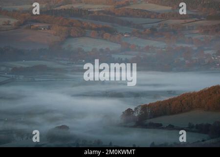 Il sole sorge su una nebbia del Worcestershire come si vede dalle colline Malvern. Il Regno Unito si sta preparando per una crisi ghiacciata mentre gli esperti dicono che l’aria artica si muoverà da mercoledì sera, con l’Agenzia britannica per la salute e la sicurezza che emette un allarme per le basse temperature che raccomanda alle persone di riscaldare le proprie case ad almeno 18C (64,4F). Data immagine: Mercoledì 7 dicembre 2022. Foto Stock